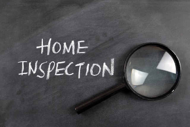 The words "Home Inspection" written in chalk beside a magnifying glass